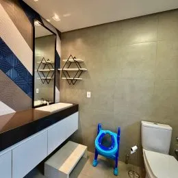 Vista de um cômodo interno com espelho e bancada em um imóvel.