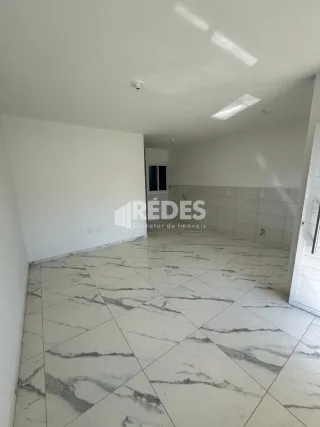 Sala ampla com piso de porcelanato claro.