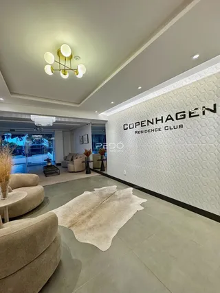 Sala de estar moderna com decoração clara e piso de porcelanato.