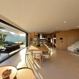 Sala ampla com piso de madeira e vista externa.