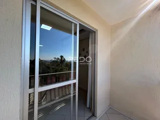 Vista de uma porta de vidro que se abre para uma área externa com vegetação.