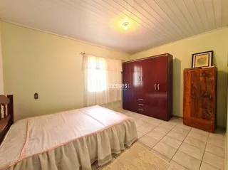 Quarto com cama e armário de madeira no interior da residência.