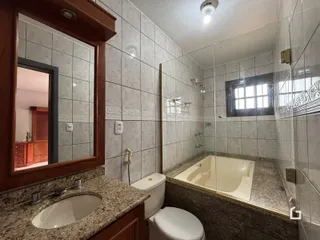 Foto de um banheiro com box de vidro e banheira em Lajeado.