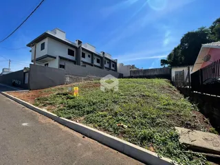 Vista externa de uma residência em Lajeado, Brasil, com muro e vegetação no quintal.