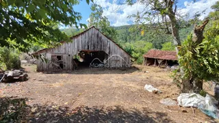 Fachada de um celeiro de madeira rústico em uma área rural.