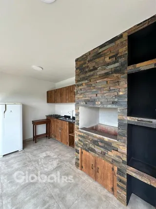 Foto de uma cozinha com paredes de pedra e armários de madeira.
