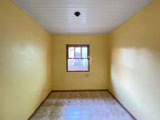 Foto de um cômodo interno com paredes amarelas e piso de cerâmica.