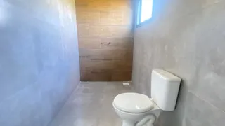 Foto de um banheiro com revestimento de parede em tons de cinza e painel de madeira na parede do fundo.