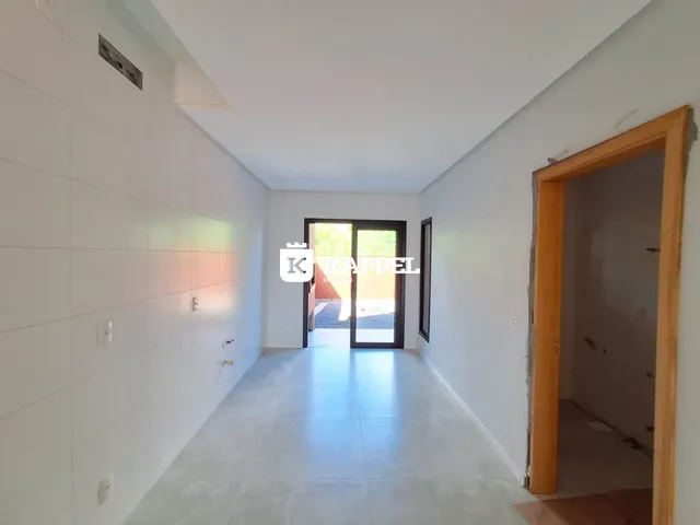 Foto de um corredor interno de uma residência com paredes brancas e piso claro.
