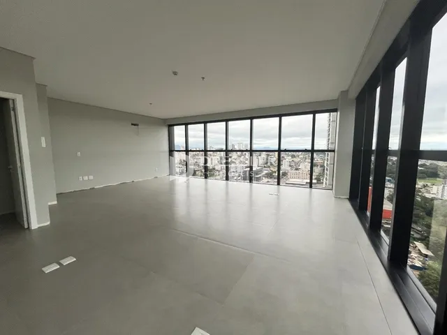 Ambiente interno amplo com grandes janelas que oferecem vista da cidade.