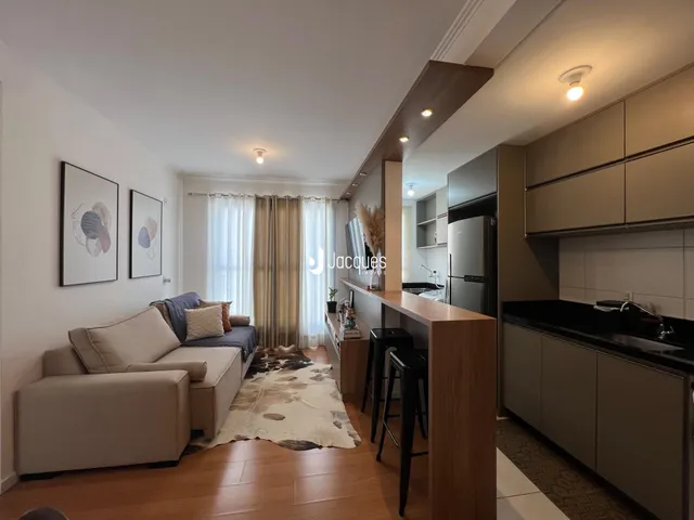 Sala de estar com piso de madeira e decoração moderna em Lajeado.