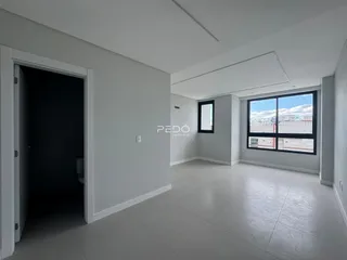 Interior de uma sala de estar com porta de acesso a um banheiro.