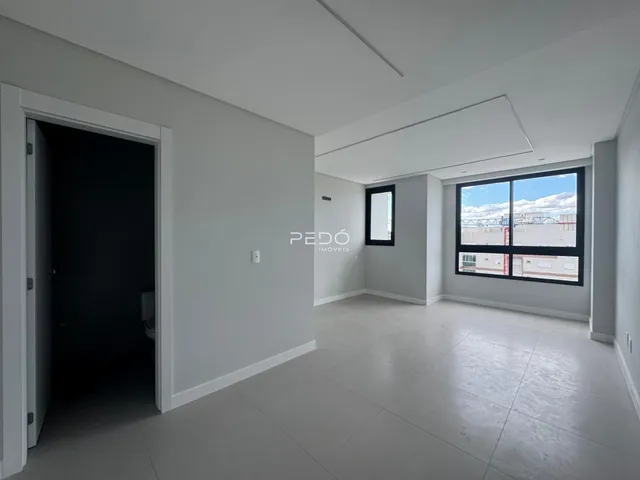 Interior de uma sala de estar com porta de acesso a um banheiro.