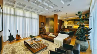 Sala de estar com piso de madeira e grandes janelas em um imóvel no Brasil.