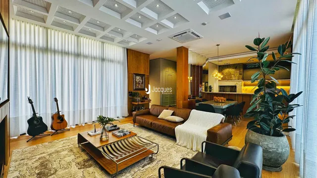 Sala de estar com piso de madeira e grandes janelas em um imóvel no Brasil.