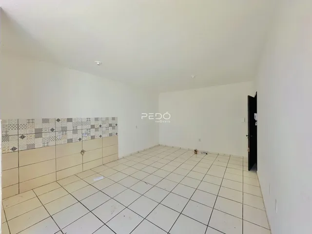 Interior de um ambiente com piso de cerâmica e parede decorada em ladrilhos.
