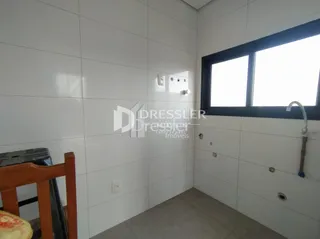 Vista interna de um corredor com paredes brancas e piso claro.