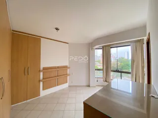 Ambiente interno de uma sala com piso de cerâmica clara e armários de madeira.