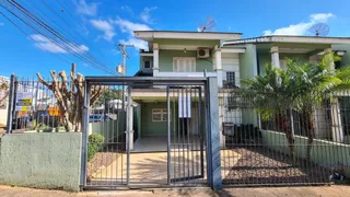 Fachada de uma residência em Lajeado, Brasil, com portão de metal e vegetação.