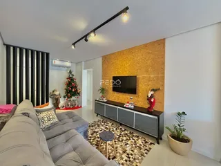 Sala de estar com sofá e parede de destaque de madeira.
