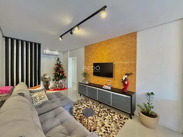 Sala de estar com sofá e parede de destaque de madeira.