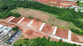 Vista aérea de um terreno com áreas de terra cultivada e vegetação densa ao redor.