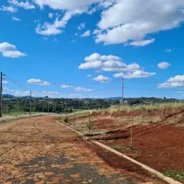 Uma paisagem de terra vermelha sob um céu azul com nuvens.