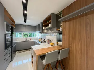 Cozinha moderna com armários cinzas e bancadas claras em um imóvel no Brasil.