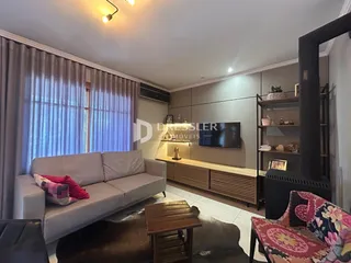 Sala de estar com sofá cinza e móveis de madeira.