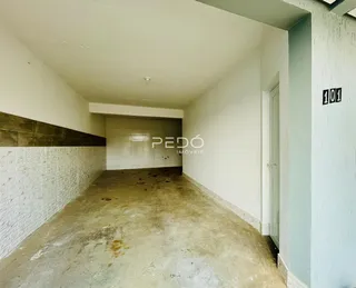 Hall de entrada com piso de concreto e revestimento cerâmico na propriedade.