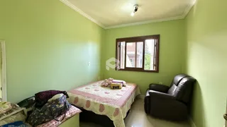Quarto com cama e poltrona em sala de estar.