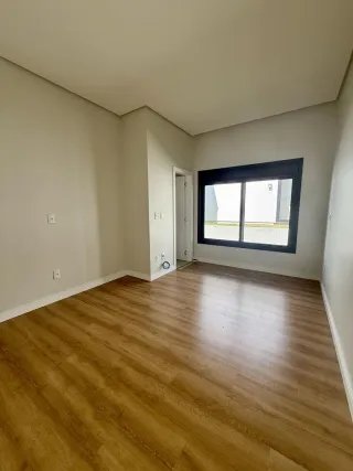 Ambiente interno com piso de madeira e janela.
