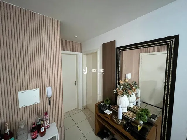 Interior de um corredor com parede texturizada e piso de cerâmica.