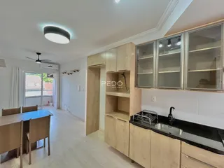 Área comum de uma residência em Lajeado, Brasil, mostrando armários de madeira e piso claro.