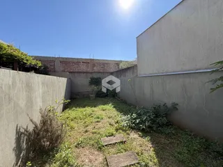 Vista externa de um terreno com vegetação e muros altos.