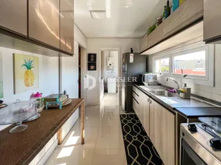Vista da cozinha com armários e bancadas em um imóvel no Brasil.