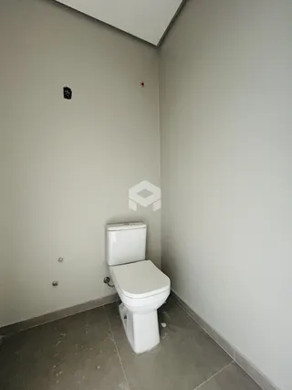 Foto de um banheiro com piso de cerâmica e paredes claras.