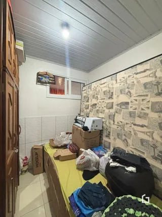 Interior de uma sala com armário de madeira e parede decorada.