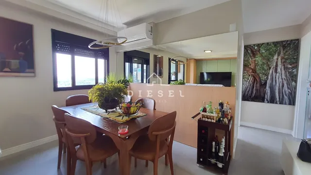 Uma sala de jantar com mesa de madeira e cadeiras.