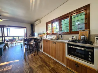 Foto de uma área de estar e cozinha em um imóvel com piso de madeira.