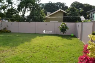 Vista externa do quintal com gramado e muro em Lajeado, Brasil.