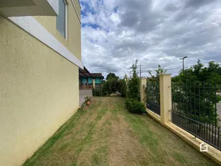 Vista da fachada de uma residência em Lajeado, Brasil, mostrando a parede e o quintal gramado.