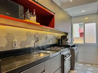 Vista da cozinha moderna com armários cinzas e revestimento hexagonal.