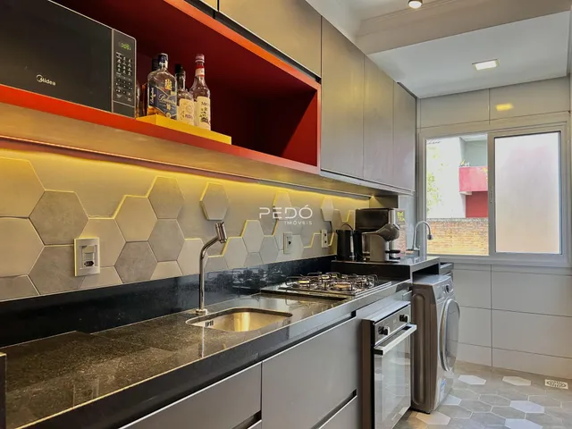 Vista da cozinha moderna com armários cinzas e revestimento hexagonal.