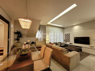 Sala de estar moderna com sofá e televisão em um imóvel no Brasil.