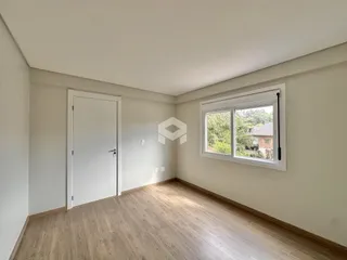 Ambiente interno com piso de madeira e janela.