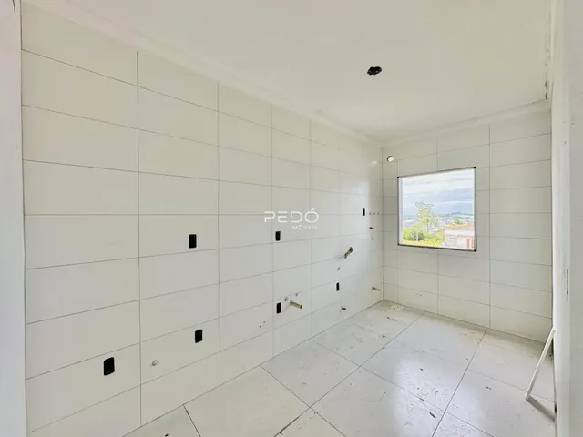 Vista interna de um ambiente com paredes brancas e piso de cerâmica.