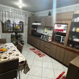 Cozinha com armários de madeira e piso de cerâmica.
