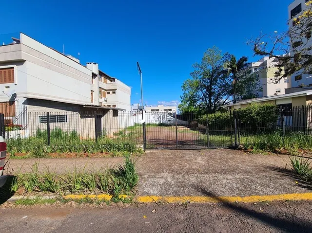Vista externa de uma propriedade com cerca e vegetação no primeiro plano.