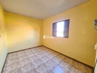 Foto de um cômodo interno com paredes amarelas e piso de cerâmica.